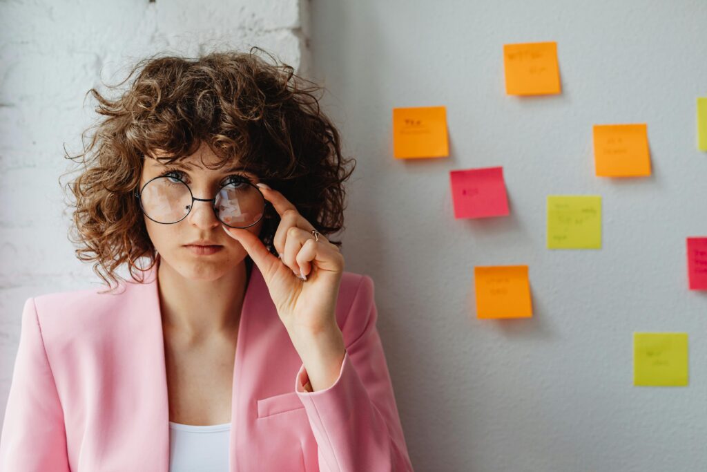 Travail collaboratif et créativité, femme observant attentivement devant un mur de post-it